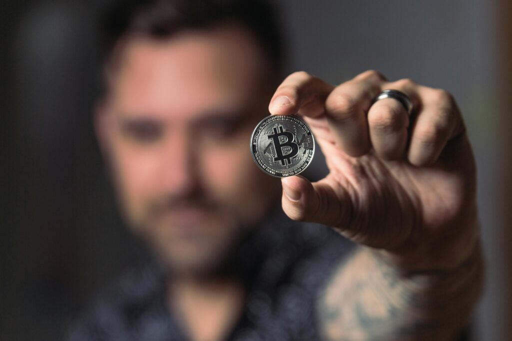 Person Holding Silver Bitcoin Coin by Crypto Crow