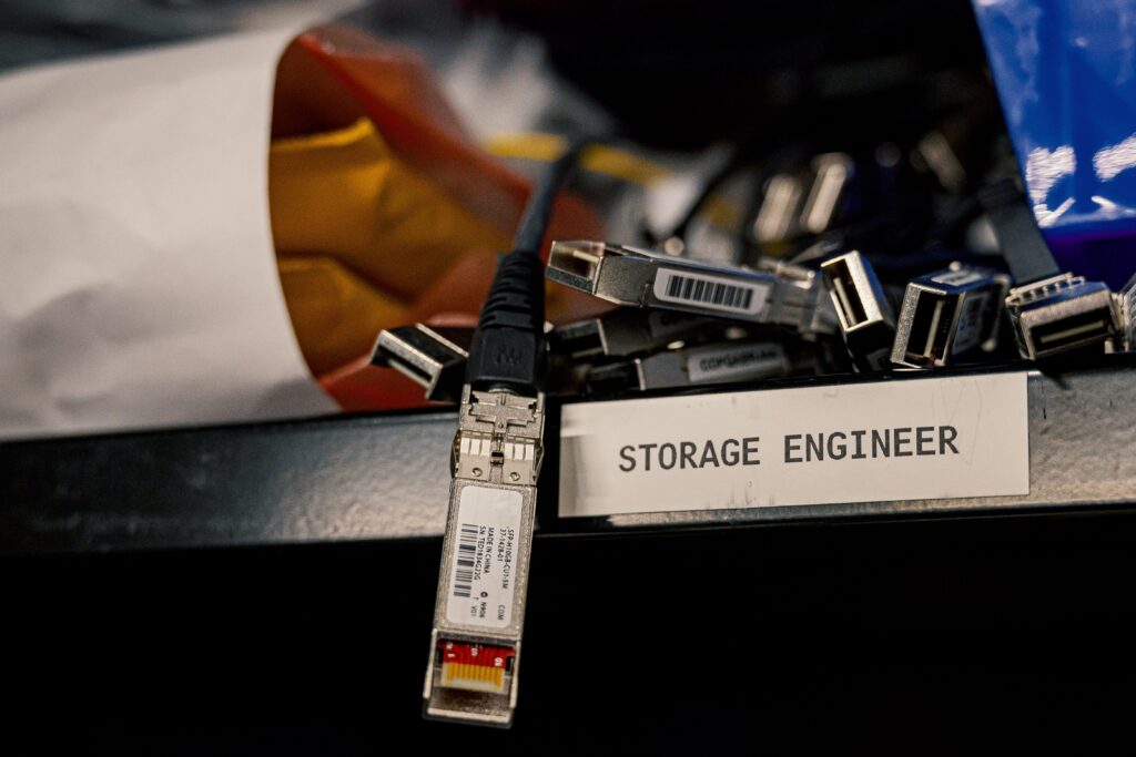 Low angle of various connectors and USB cables placed on shelf with storage engineer inscription by Brett Sayles