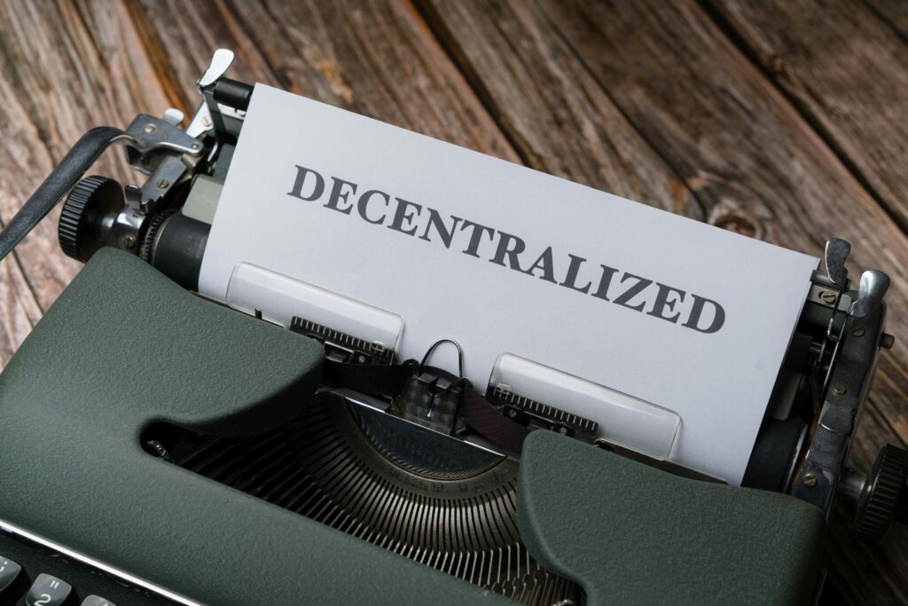 A typewriter with a paper that says decentalized by Markus Winkler