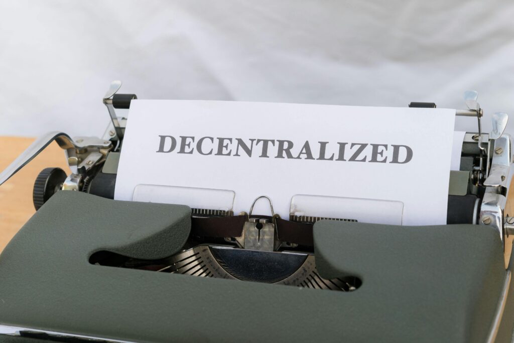 A typewriter with a paper that says decentralized by Markus Winkler