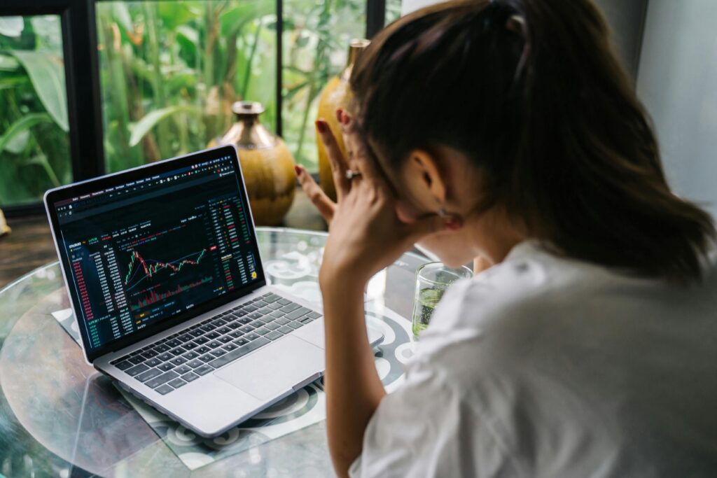 Woman Looking at Cryptocurrency Charts on Her Laptop  by Anna Tarazevich