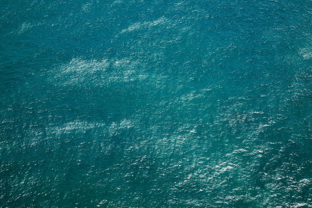 Drone view of rippling azure pure water of sea with little waves running on surface by Laker